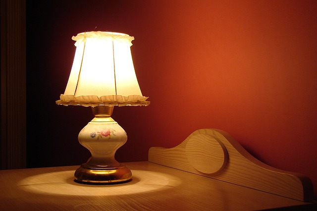 rozsvícená lampička na nočním stolku
